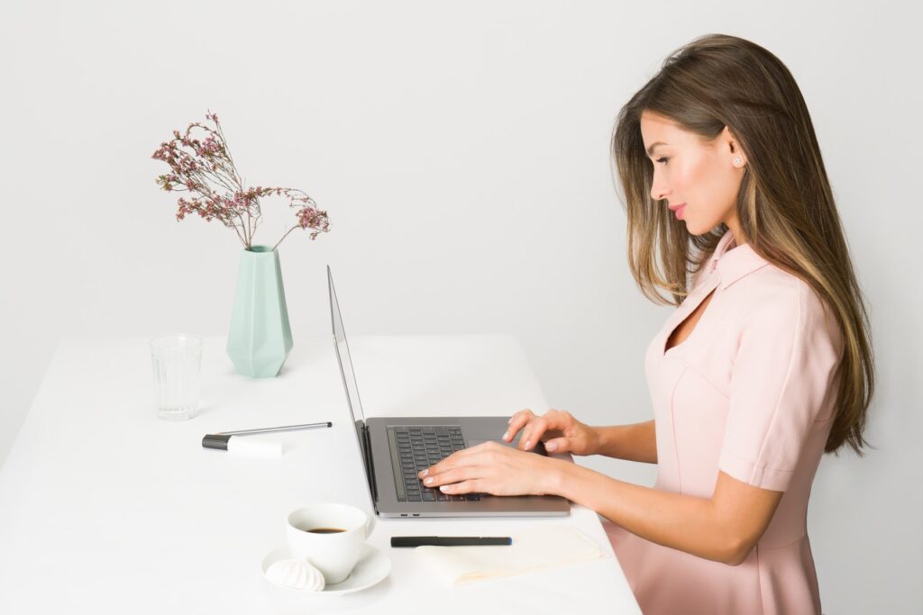 En la imagen aparece una mujer tecleando su ordenador portátil