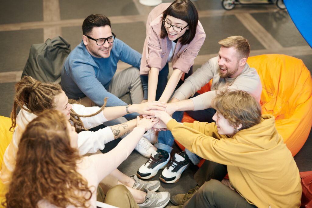 Imagen en la que aparece un grupo de personas de un mismo equipo de trabajo uniendo sus manos a modo de logro o consecución de objetivos